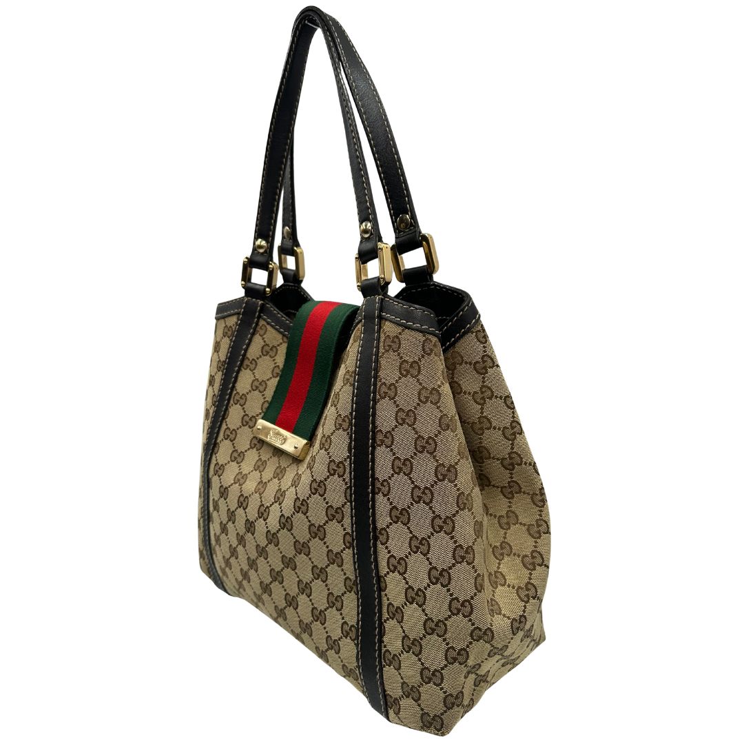 lato Borsa Gucci in tessuto GG beige con finiture in pelle marroni, impreziosita da da striscia Web sulla chiusura verde e rossa e parti metalliche dorate; munita di doppi manici, da portare a spalla, di lusso, originale, usata. 