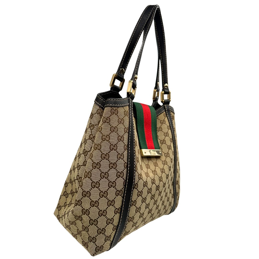 lato Borsa Gucci in tessuto GG beige con finiture in pelle marroni, impreziosita da da striscia Web sulla chiusura verde e rossa e parti metalliche dorate; munita di doppi manici, da portare a spalla, di lusso, originale, usata.
