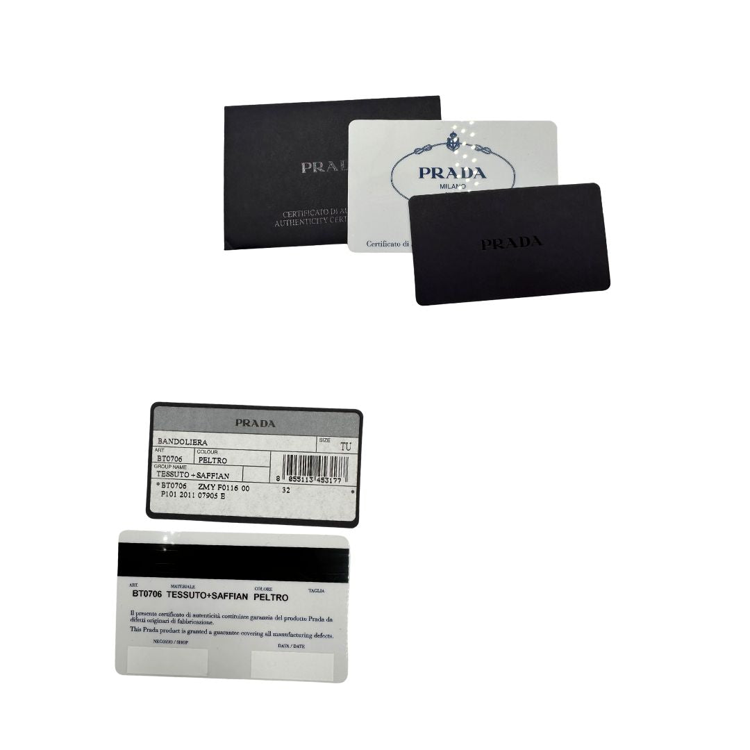 Crtellini di una Borsa Prada in nylon Grigia con finiture in pelle nera e parti metalliche dorate; munita di una tracolla in tessuto regolabile e tag porta address. Originale, usata, di lusso in ottime condizioni.