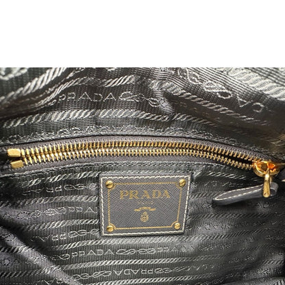 Interno di una Borsa Prada in nylon Grigia con finiture in pelle nera e parti metalliche dorate; munita di una tracolla in tessuto regolabile e tag porta address. Originale, usata, di lusso in ottime condizioni.