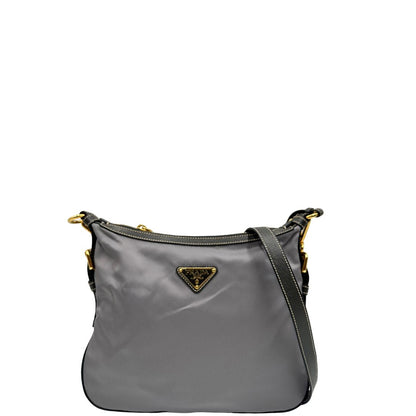 Front di una Borsa Prada in nylon Grigia con finiture in pelle nera e parti metalliche dorate; munita di una tracolla in tessuto regolabile e tag porta address. Originale, usata, di lusso in ottime condizioni.