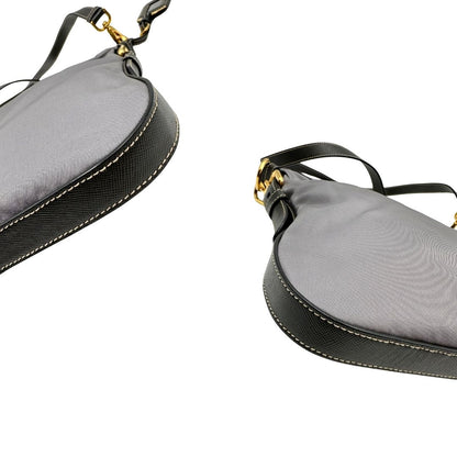 Angoli di una Borsa Prada in nylon Grigia con finiture in pelle nera e parti metalliche dorate; munita di una tracolla in tessuto regolabile e tag porta address. Originale, usata, di lusso in ottime condizioni.