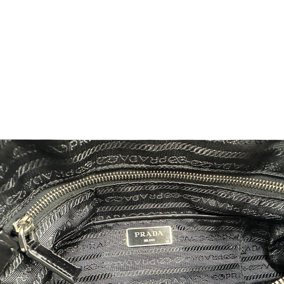 interno Borsa Prada in nylon con grafica decorativa e finiture in pelle nere e parti metalliche argentate; munita di doppi manici stondati e una tracolla amovibile e regolabile. Completa di corredo, di lusso, originale, ottime condizioni. 