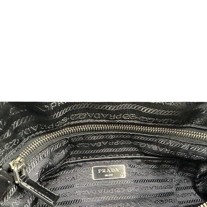 interno Borsa Prada in nylon con grafica decorativa e finiture in pelle nere e parti metalliche argentate; munita di doppi manici stondati e una tracolla amovibile e regolabile. Completa di corredo, di lusso, originale, ottime condizioni. 