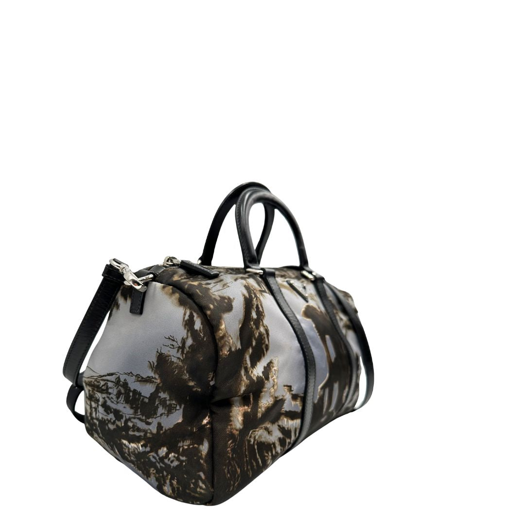 lato Borsa Prada in nylon con grafica decorativa e finiture in pelle nere e parti metalliche argentate; munita di doppi manici stondati e una tracolla amovibile e regolabile. Completa di corredo, di lusso, originale, ottime condizioni. 