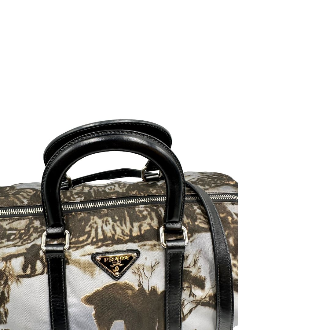 manici Borsa Prada in nylon con grafica decorativa e finiture in pelle nere e parti metalliche argentate; munita di doppi manici stondati e una tracolla amovibile e regolabile. Completa di corredo, di lusso, originale, ottime condizioni. 