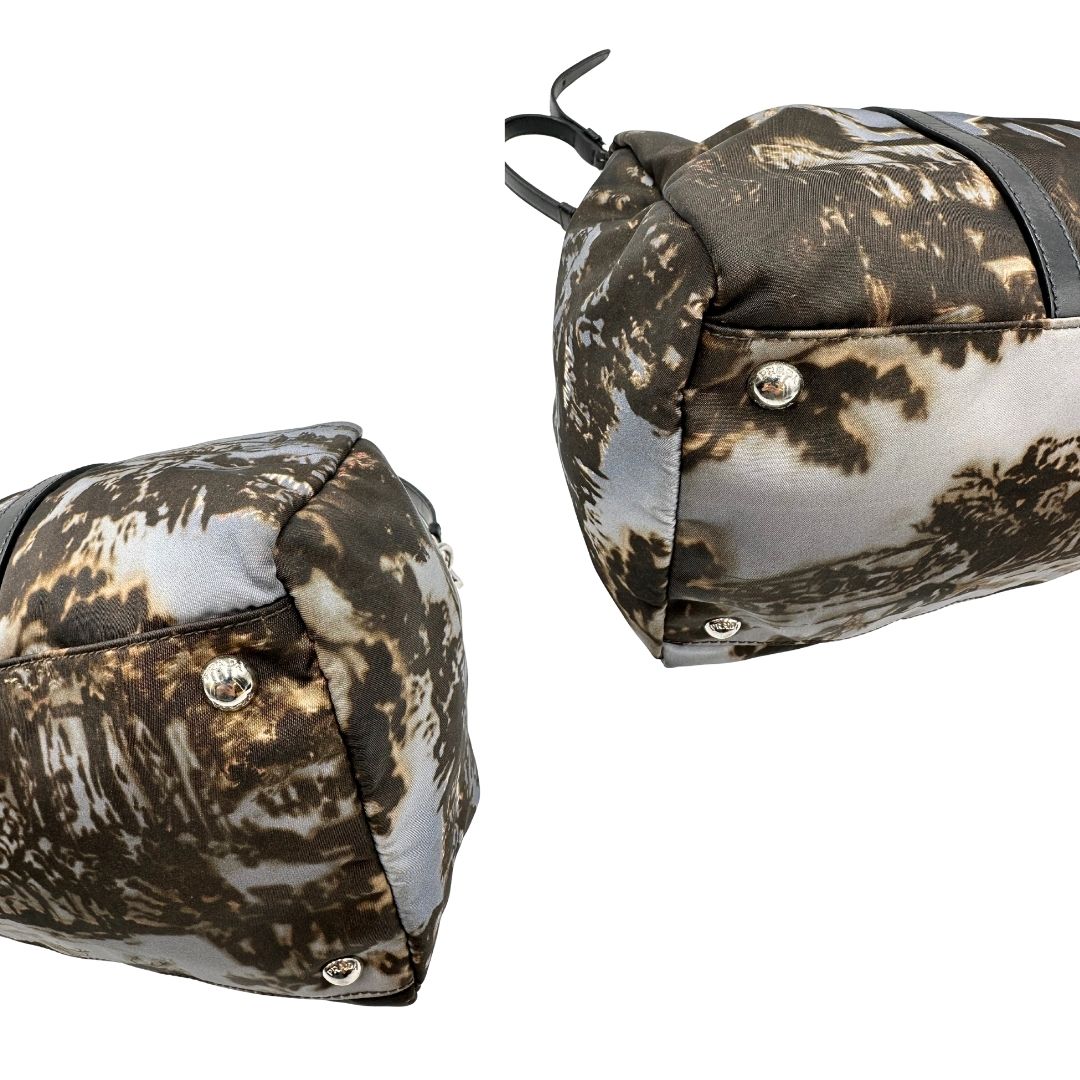 angoli Borsa Prada in nylon con grafica decorativa e finiture in pelle nere e parti metalliche argentate; munita di doppi manici stondati e una tracolla amovibile e regolabile. Completa di corredo, di lusso, originale, ottime condizioni. 