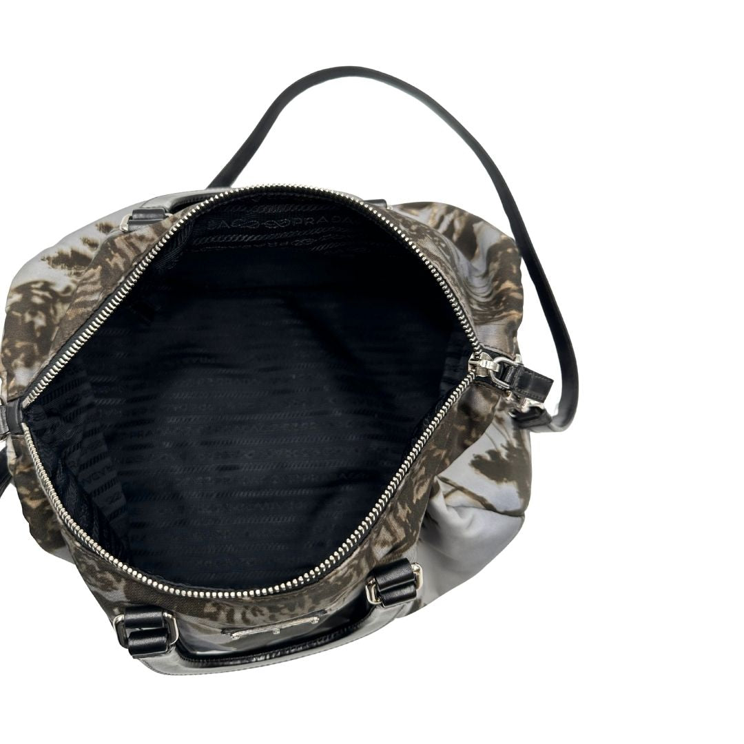 interno Borsa Prada in nylon con grafica decorativa e finiture in pelle nere e parti metalliche argentate; munita di doppi manici stondati e una tracolla amovibile e regolabile. Completa di corredo, di lusso, originale, ottime condizioni. 