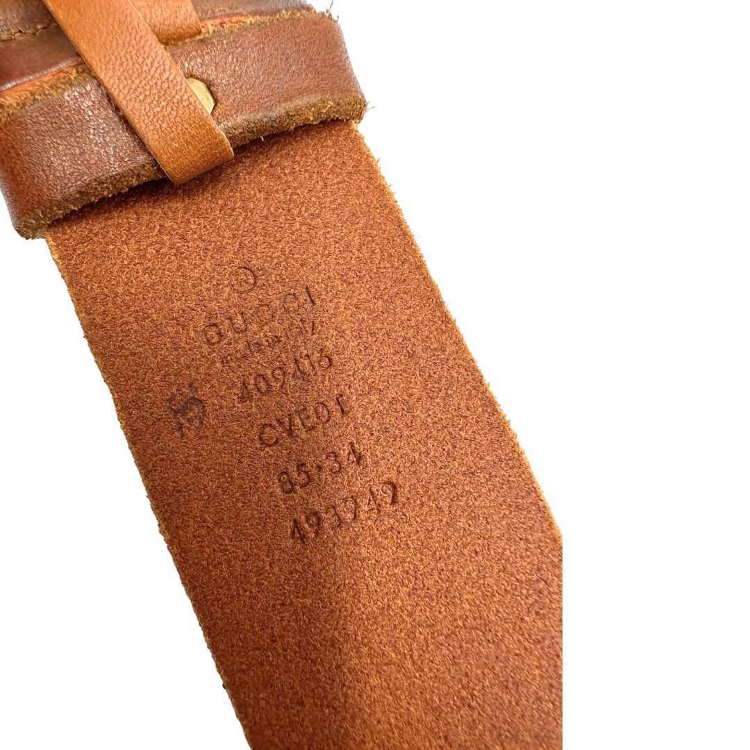 Cintura Gucci in pelle marrone bruciato, fibbia GG in metallo dorato. Completa di dustbag. Originale, usato, di lusso, in ottime condizioni.