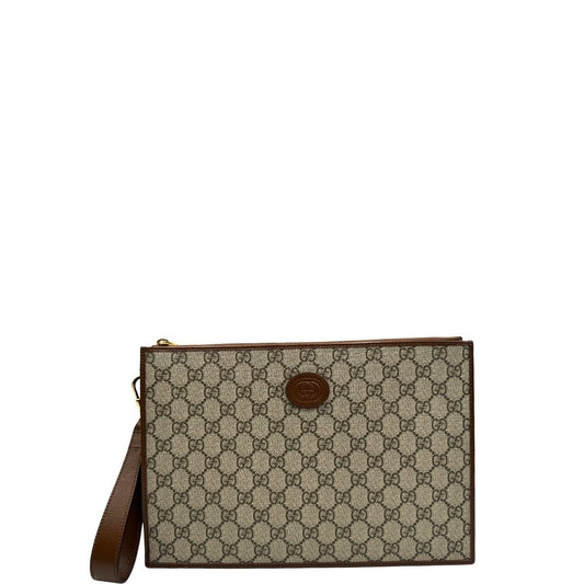 Front di una Pochette Gucci in canvas GG monogram beige con finiture in pelle marroni e parti metalliche dorate; munita di un pulsino in pelle amovibile, indossabile a mano. Completa di scatola e dustbag. Originale, usata, di lusso, in condizioni eccellenti.