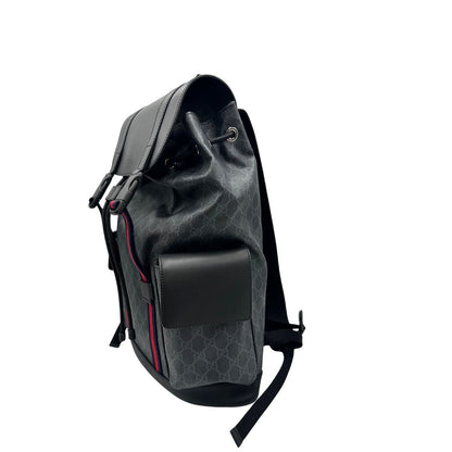 Lato sinistro di un Zaino Gucci in canvas grigio GG con finiture in pelle neri e parti metalliche argentate. Iconica striscia Web in blu/rosso sul front, munito di un manico singolo, Bretelle imbottite regolabili e patta con moschettoni a scatto. Completo di dustbag. Originale, usato, di lusso, in condizioni eccellenti.