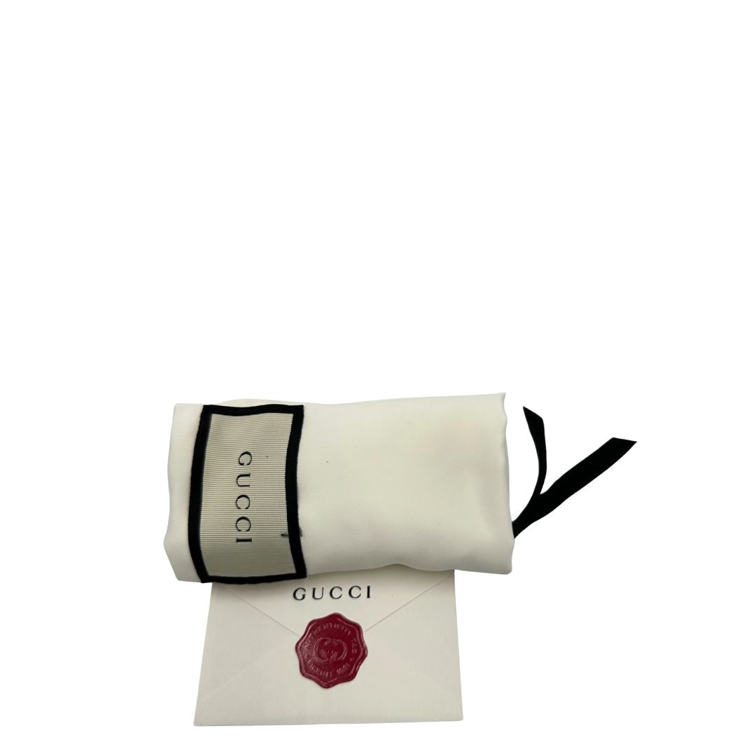 Dustbag di una Borsa Gucci Marmont in pelle nera con motivo chevron, parti metalliche dorate, munita di un manico in catena e spallaccio in pelle non regolabile ; indossabile a spalla. Completa di dustbag. Originale, usata, di lusso, in condizioni eccellenti.