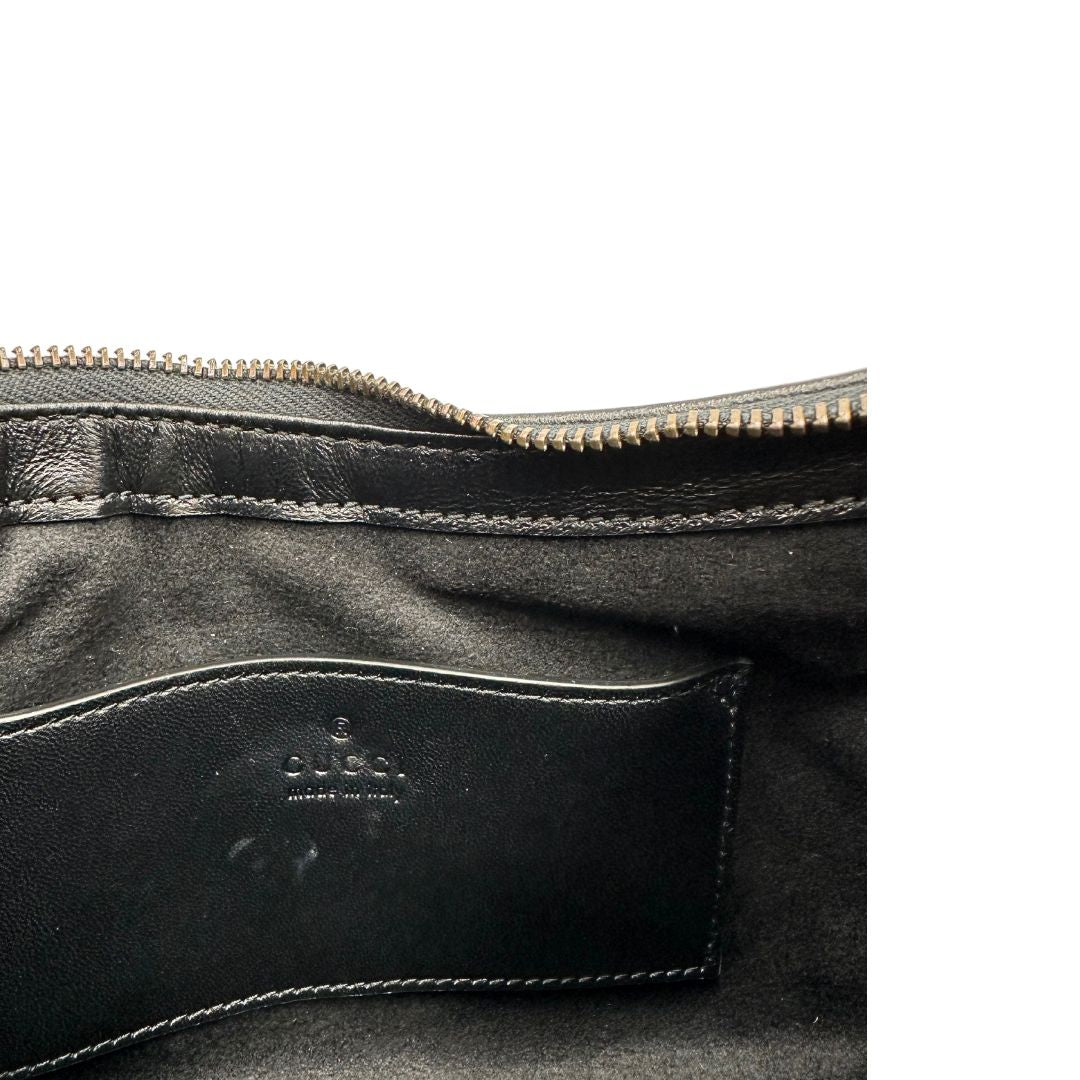 Interno di una Borsa Gucci Marmont in pelle nera con motivo chevron, parti metalliche dorate, munita di un manico in catena e spallaccio in pelle non regolabile ; indossabile a spalla. Completa di dustbag. Originale, usata, di lusso, in condizioni eccellenti.