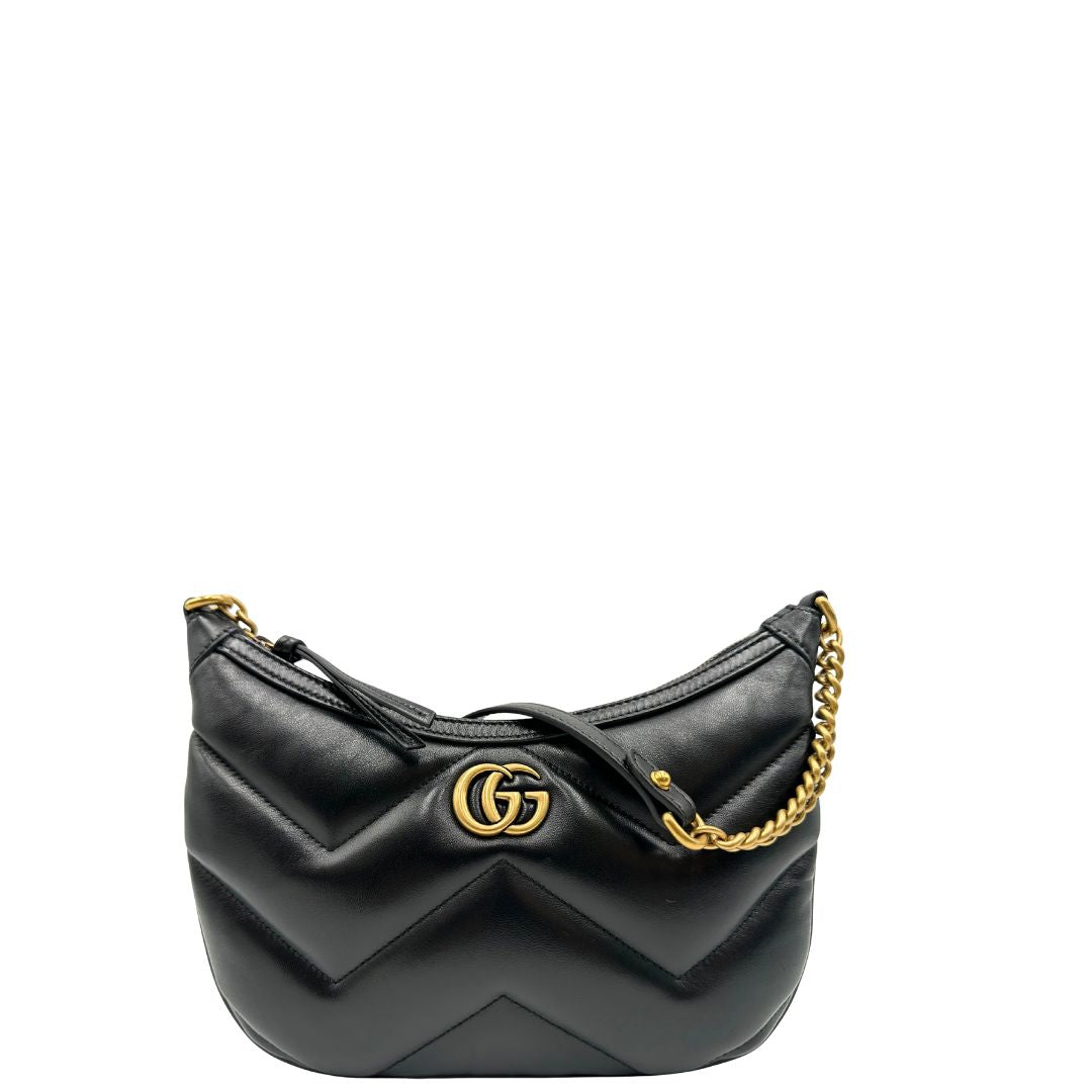 Front di una Borsa Gucci Marmont in pelle nera con motivo chevron, parti metalliche dorate, munita di un manico in catena e spallaccio in pelle non regolabile ; indossabile a spalla. Completa di dustbag. Originale, usata, di lusso, in condizioni eccellenti.