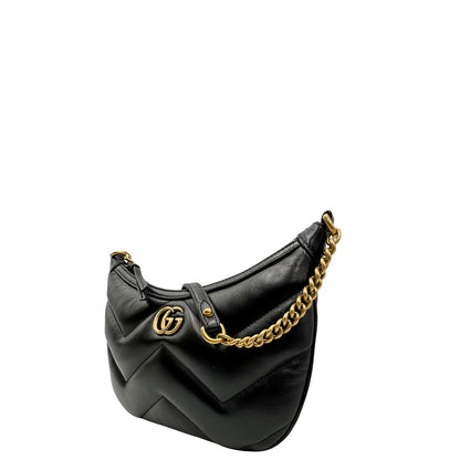 Lato sinistro di una Borsa Gucci Marmont in pelle nera con motivo chevron, parti metalliche dorate, munita di un manico in catena e spallaccio in pelle non regolabile ; indossabile a spalla. Completa di dustbag. Originale, usata, di lusso, in condizioni eccellenti.