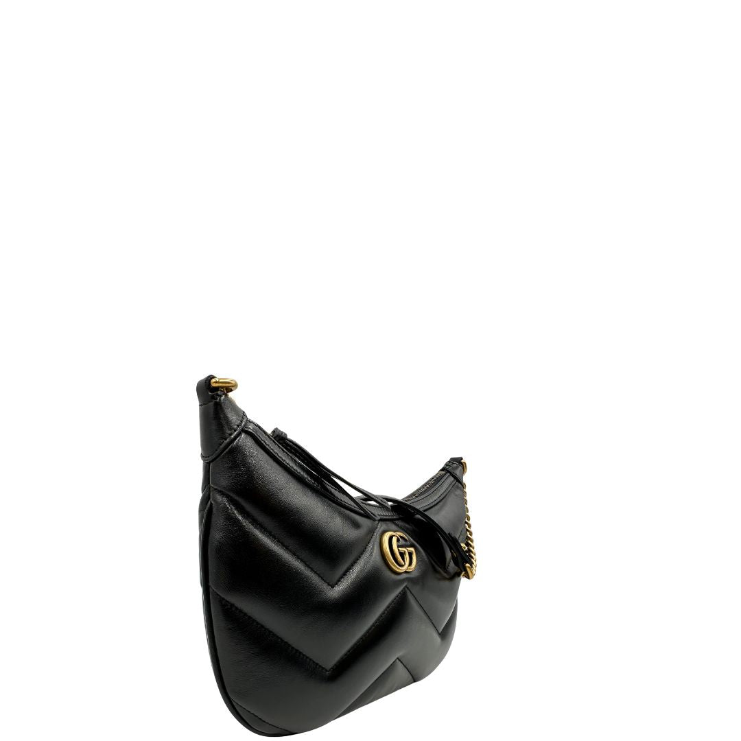 Angolo destro di una Borsa Gucci Marmont in pelle nera con motivo chevron, parti metalliche dorate, munita di un manico in catena e spallaccio in pelle non regolabile ; indossabile a spalla. Completa di dustbag. Originale, usata, di lusso, in condizioni eccellenti.