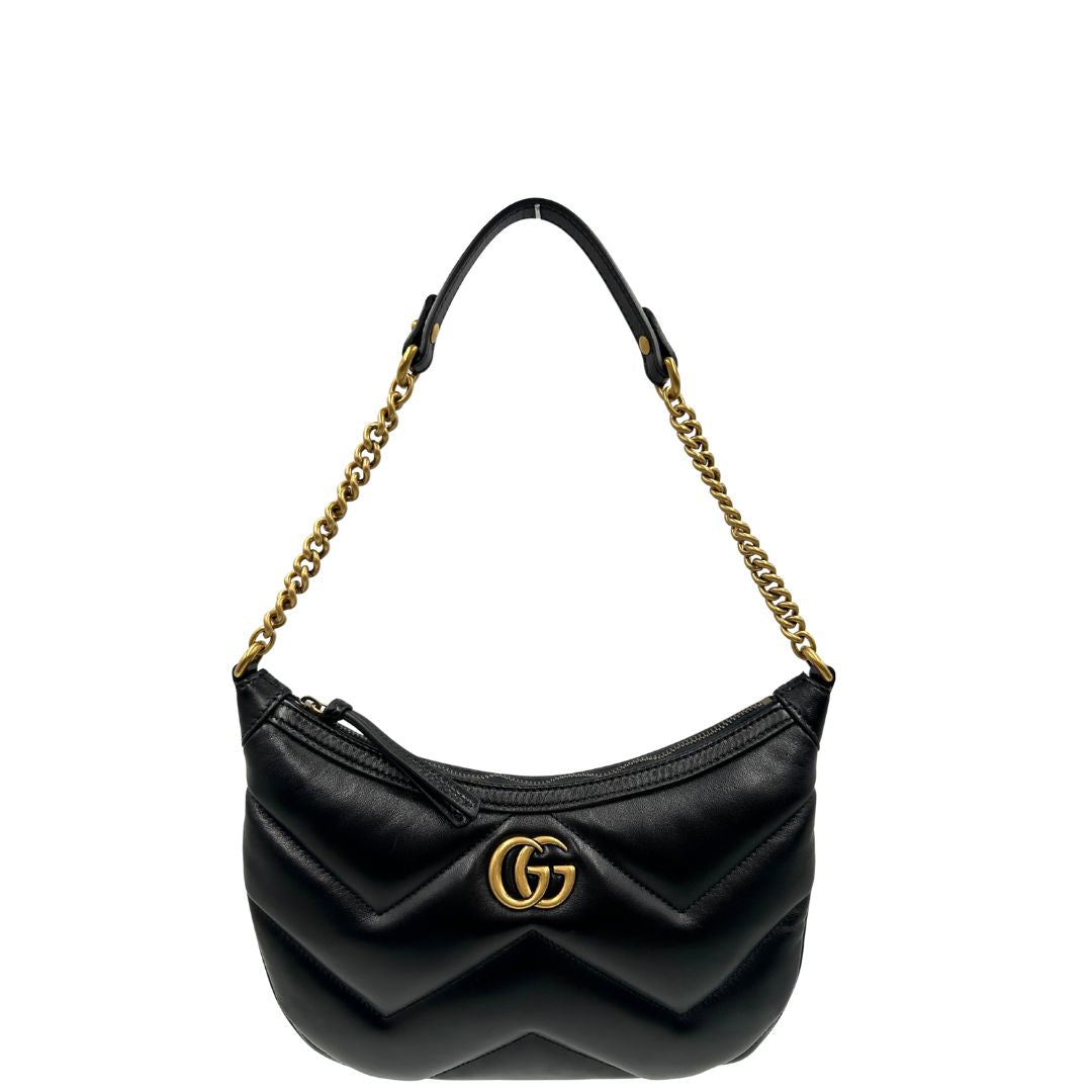Front di una Borsa Gucci Marmont in pelle nera con motivo chevron, parti metalliche dorate, munita di un manico in catena e spallaccio in pelle non regolabile ; indossabile a spalla. Completa di dustbag. Originale, usata, di lusso, in condizioni eccellenti.