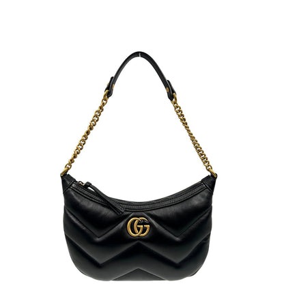 Front di una Borsa Gucci Marmont in pelle nera con motivo chevron, parti metalliche dorate, munita di un manico in catena e spallaccio in pelle non regolabile ; indossabile a spalla. Completa di dustbag. Originale, usata, di lusso, in condizioni eccellenti.