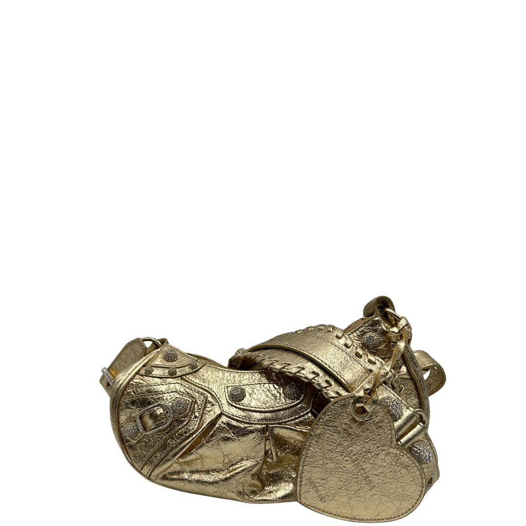 retro Borsa Balenciaga in pelle dorata con parti metalliche dorate, impreziosita da borchie con cristalli incastonati; munita di una tracolla regolabile. Completa di dustbag, di lusso, originale, ottime condizioni. 