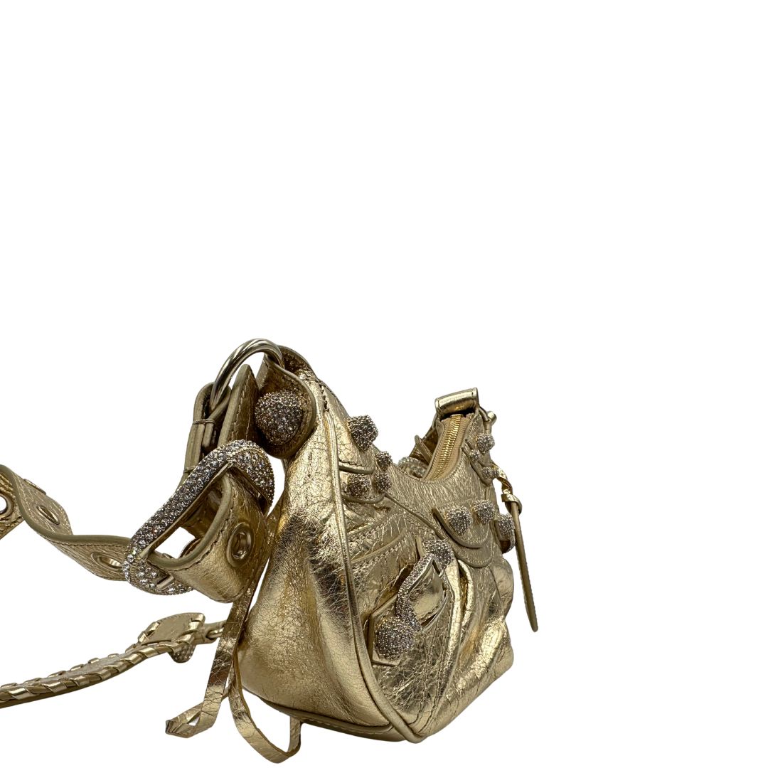 lato Borsa Balenciaga in pelle dorata con parti metalliche dorate, impreziosita da borchie con cristalli incastonati; munita di una tracolla regolabile. Completa di dustbag, di lusso, originale, ottime condizioni. 