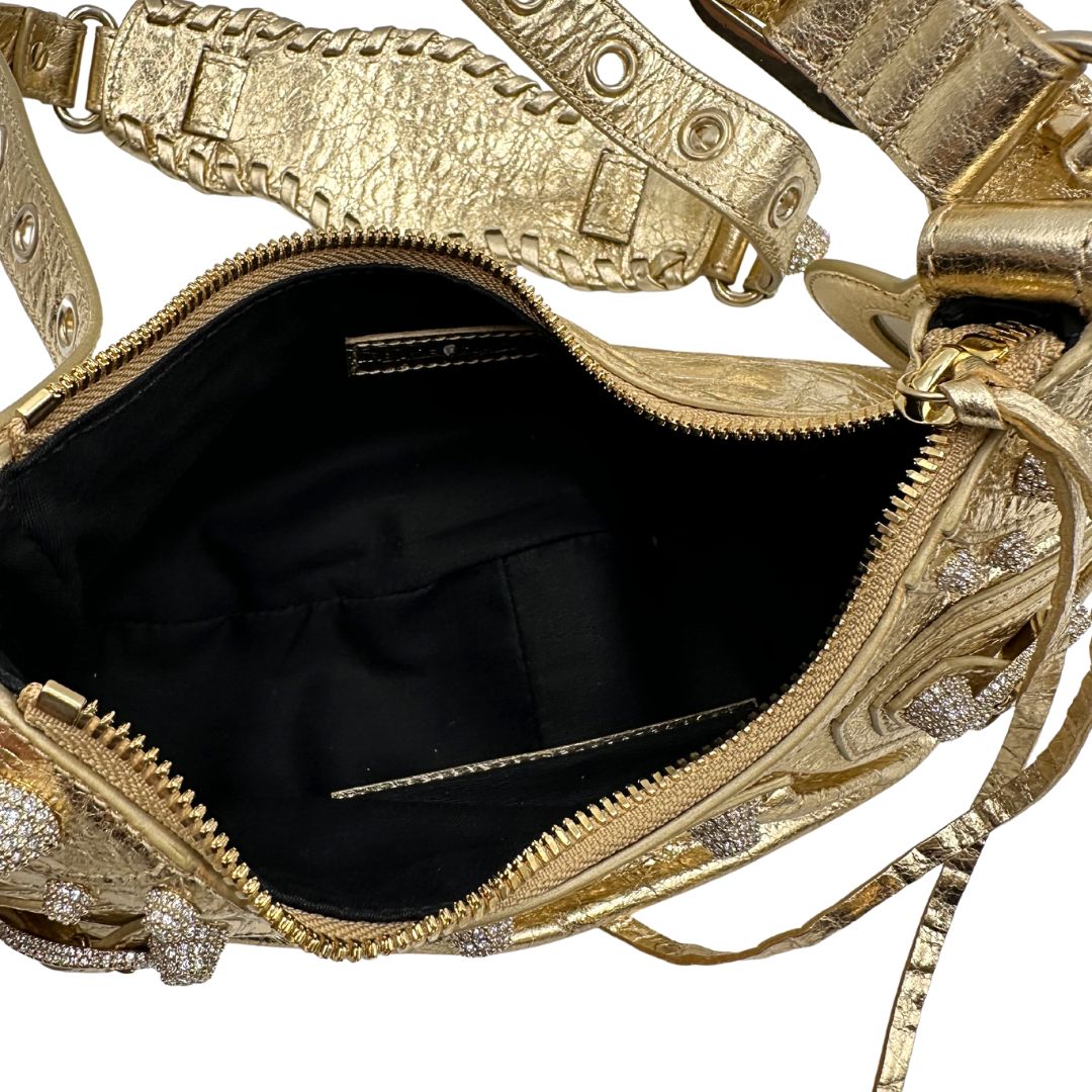 interno Borsa Balenciaga in pelle dorata con parti metalliche dorate, impreziosita da borchie con cristalli incastonati; munita di una tracolla regolabile. Completa di dustbag, di lusso, originale, ottime condizioni. 