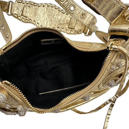 interno Borsa Balenciaga in pelle dorata con parti metalliche dorate, impreziosita da borchie con cristalli incastonati; munita di una tracolla regolabile. Completa di dustbag, di lusso, originale, ottime condizioni. 