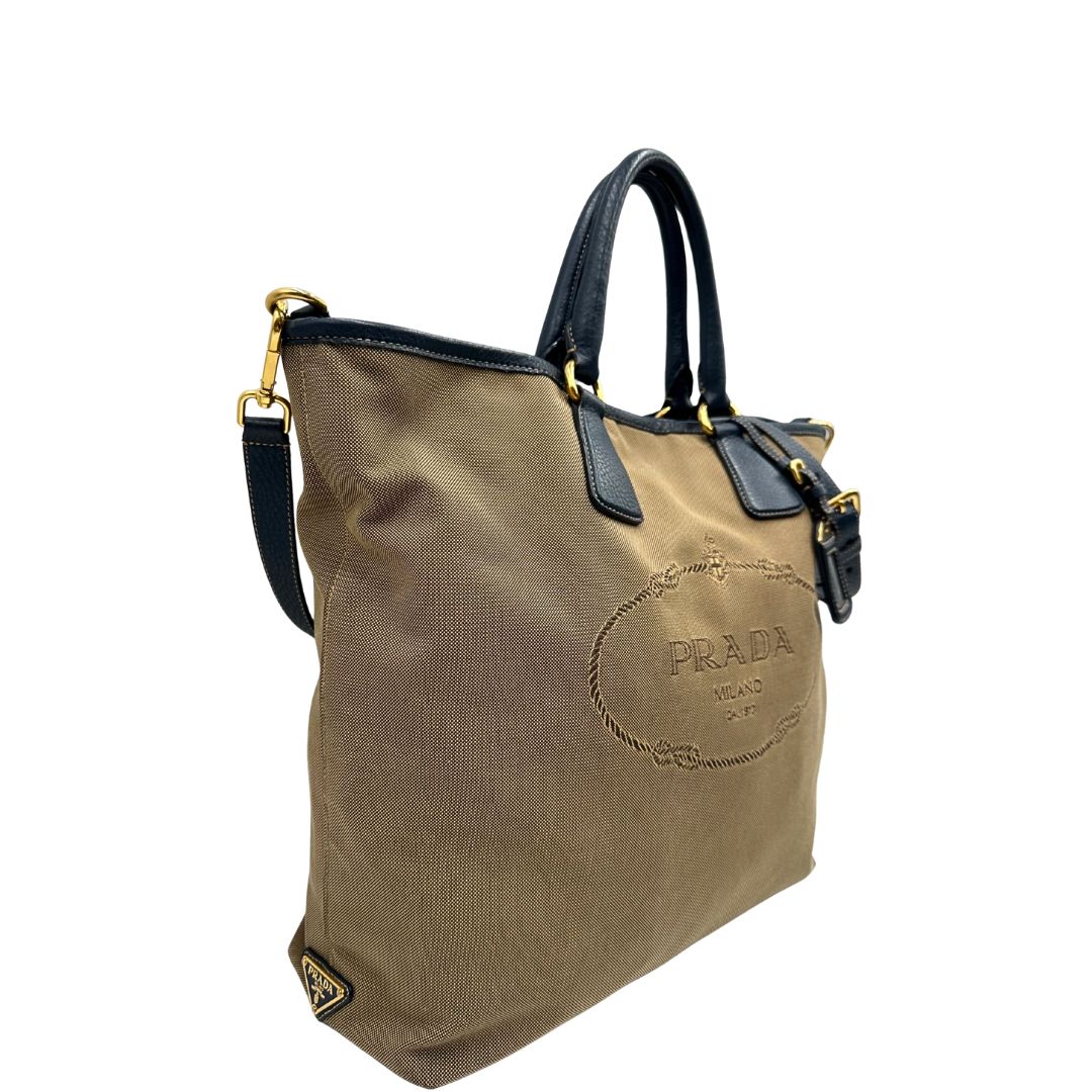 lato  Borsa Prada in tessuto color corda con logo Jacquard sul front, finiture in pelle blu e parti metalliche dorate; munita di doppi manici e una tracolla amovibile e regolabile. Completa di dustbag, ottime condizioni, usata. 