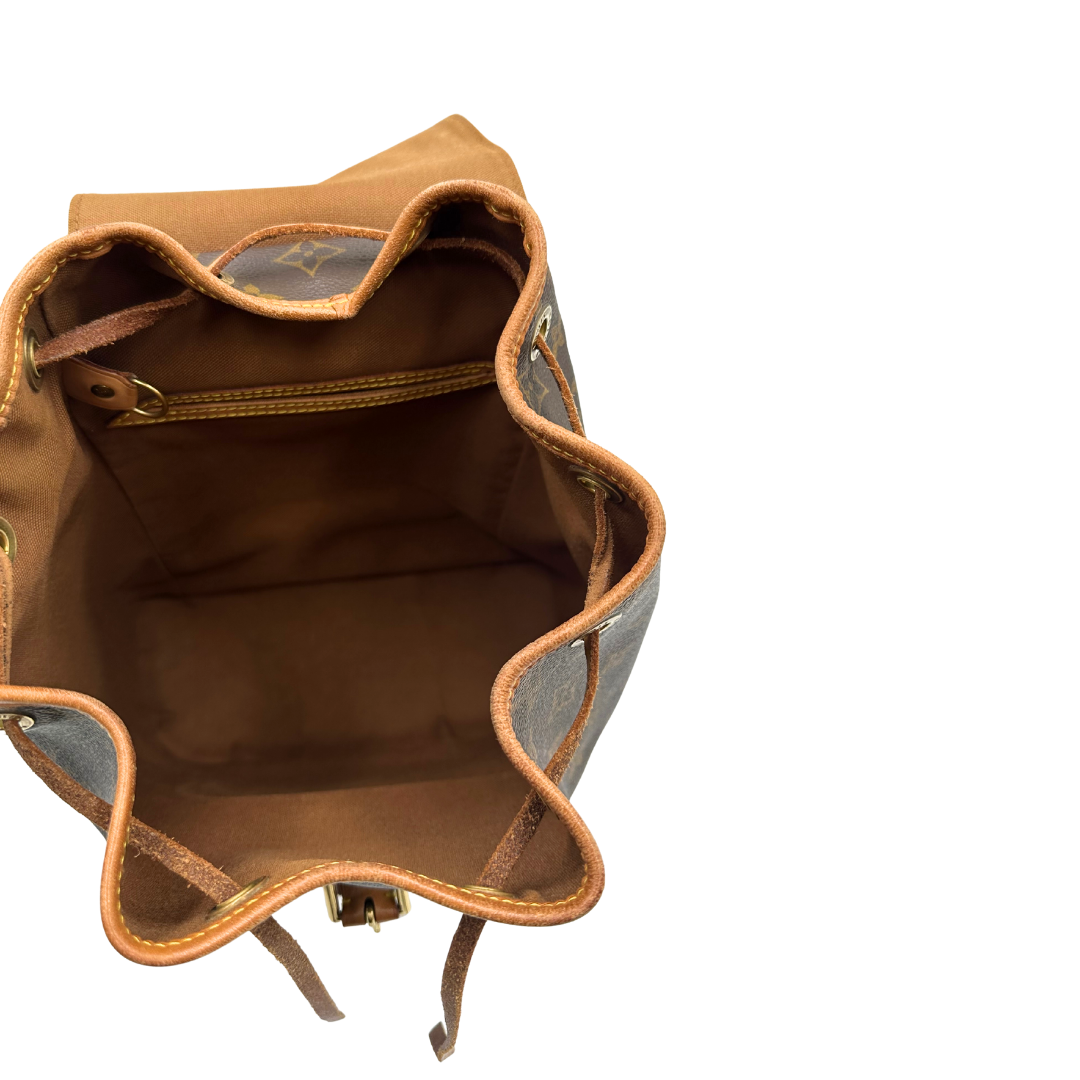 Interno di un Zaino Montsouris PM in canvas marrone monogram con finiture in vacchetta naturale e parti metalliche dorate, munito di un Anello da portare a mano e una tracolle in vacchetta regolabile con fibbie. Originale, usato , di lusso, in ottime condizioni.