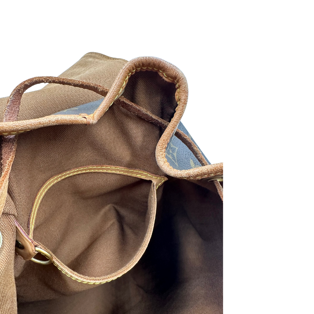 Tasca interna di un Zaino Montsouris PM in canvas marrone monogram con finiture in vacchetta naturale e parti metalliche dorate, munito di un Anello da portare a mano e una tracolle in vacchetta regolabile con fibbie. Originale, usato , di lusso, in ottime condizioni.