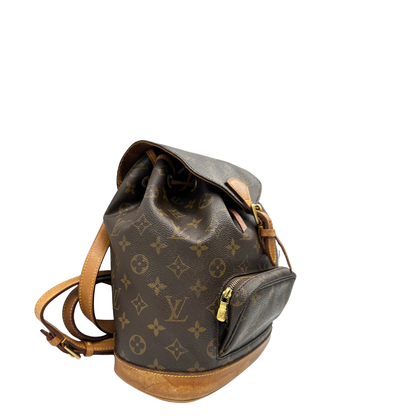 Lato destro di un Zaino Montsouris PM in canvas marrone monogram con finiture in vacchetta naturale e parti metalliche dorate, munito di un Anello da portare a mano e una tracolle in vacchetta regolabile con fibbie. Originale, usato , di lusso, in ottime condizioni.