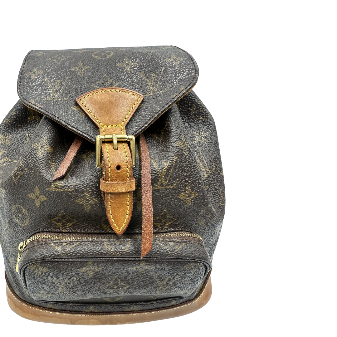 Zaino Montsouris PM in canvas marrone monogram con finiture in vacchetta naturale e parti metalliche dorate, munito di un Anello da portare a mano e una tracolle in vacchetta regolabile con fibbie. Originale, usato , di lusso, in ottime condizioni.