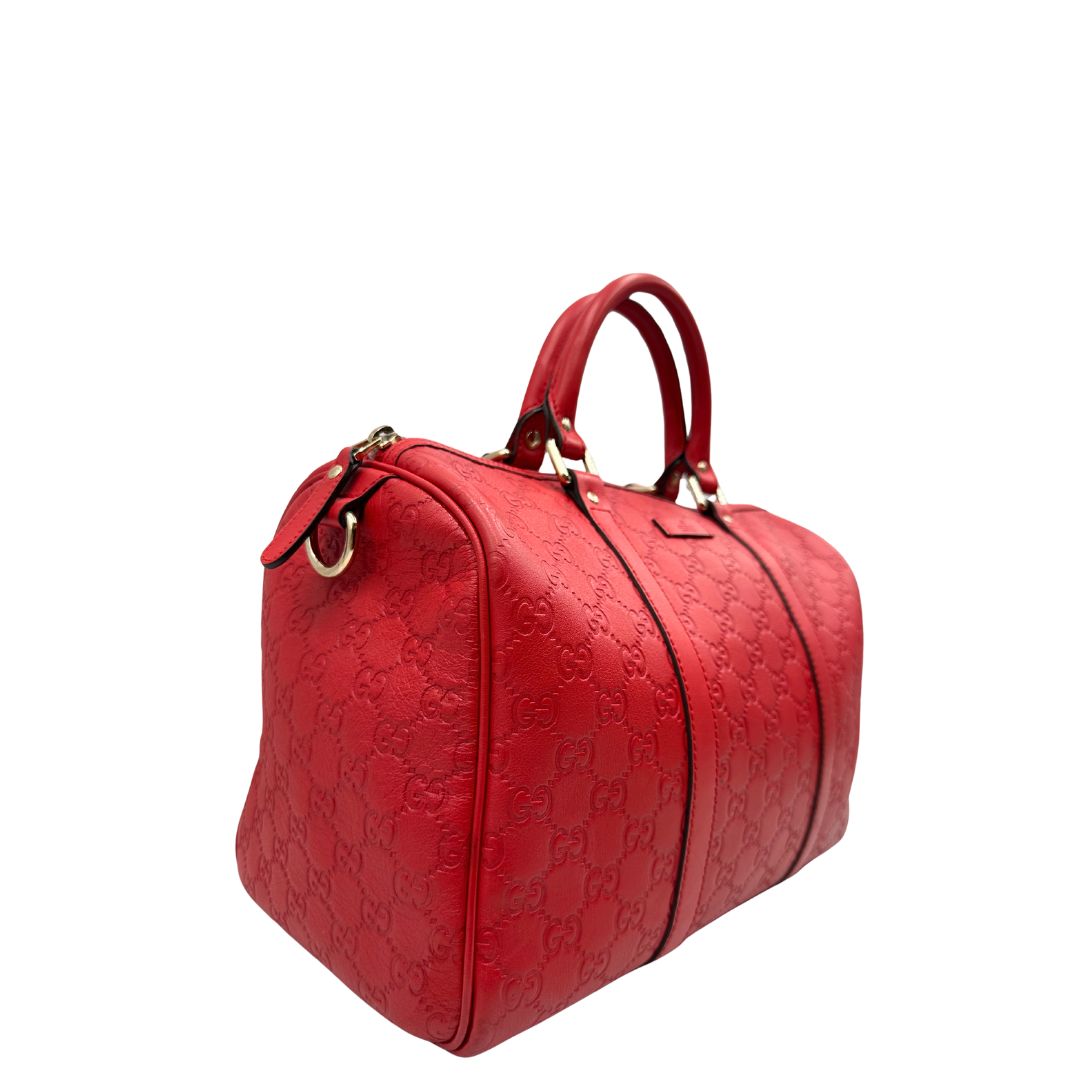 Lato destro di una Borsa Gucci in pelle color rosso GG con parti metalliche dorate; munita di doppi manici stondati , da portare a mano. Completa di dustbag. Originale, usata, di lusso, in ottime condizioni.