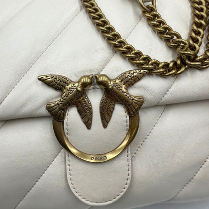 una Borsa Pinko in pelle trapuntata color bianco gesso con parti metalliche dorate; munita di una tracolla in catena scorrevole e spallaccio in pelle. Indossabile a spalla oppure a tracolla. Originale, usata, di lusso, in condizioni buone.