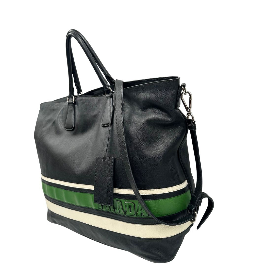 lato Borsa Prada in pelle saffiano nera con strisce verdi e bianche; munita di doppi manici e una tracolla amovibile e regolabile, di lusso, originale, ottime condizioni, usata. 
