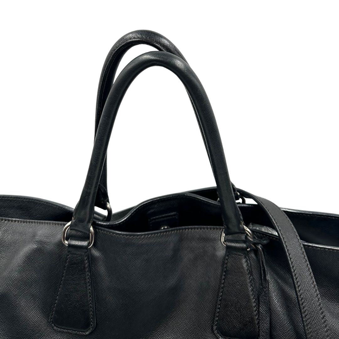 manici Borsa Prada in pelle saffiano nera con strisce verdi e bianche; munita di doppi manici e una tracolla amovibile e regolabile, di lusso, originale, ottime condizioni, usata.