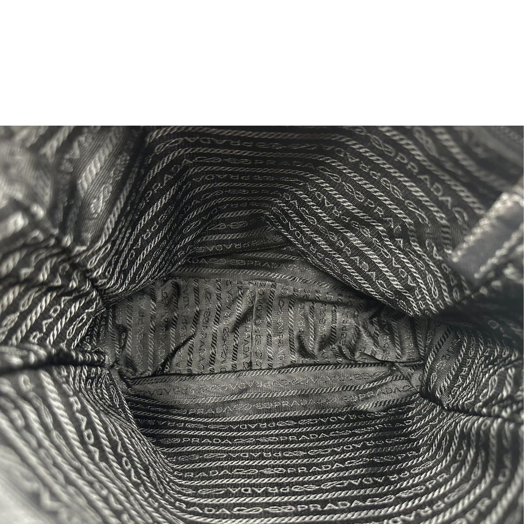 Interno di una Borsa Prada in nylon nero con finiture in pelle tono su tono e parti metalliche argentate; munita di una tracolla in tessuto regolabile. Originale, usata, di lusso, in ottime condizioni