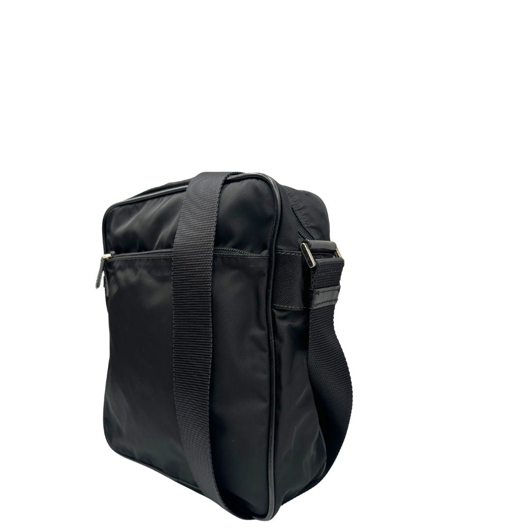 Lato sinistro di una Borsa Prada in nylon nero con finiture in pelle tono su tono e parti metalliche argentate; munita di una tracolla in tessuto regolabile. Originale, usata, di lusso, in ottime condizioni