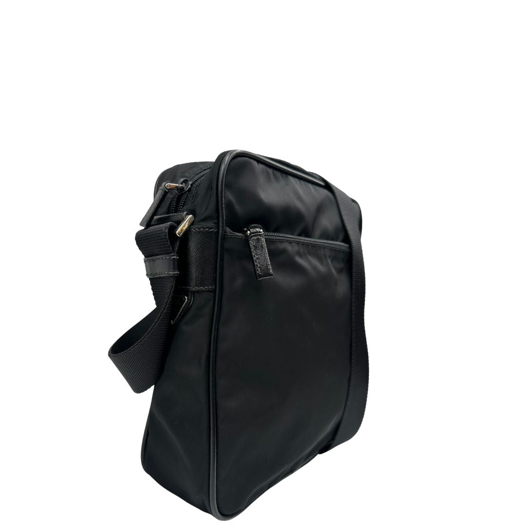 Lato destro di una Borsa Prada in nylon nero con finiture in pelle tono su tono e parti metalliche argentate; munita di una tracolla in tessuto regolabile. Originale, usata, di lusso, in ottime condizioni