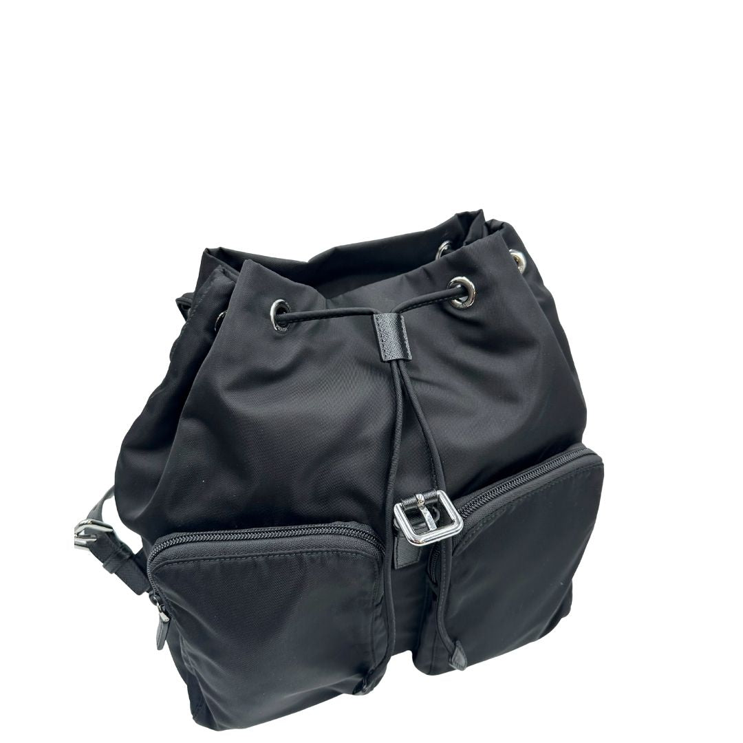 Zaino Prada in tessuto nylon nero e finiture in pelle saffiano tono su tono. Parti metalliche argentate; munito di doppie bretelle in tessuto regolabili. Completo di corredo e card d'autenticità. Originale, usato, di lusso, in condizioni eccellenti.