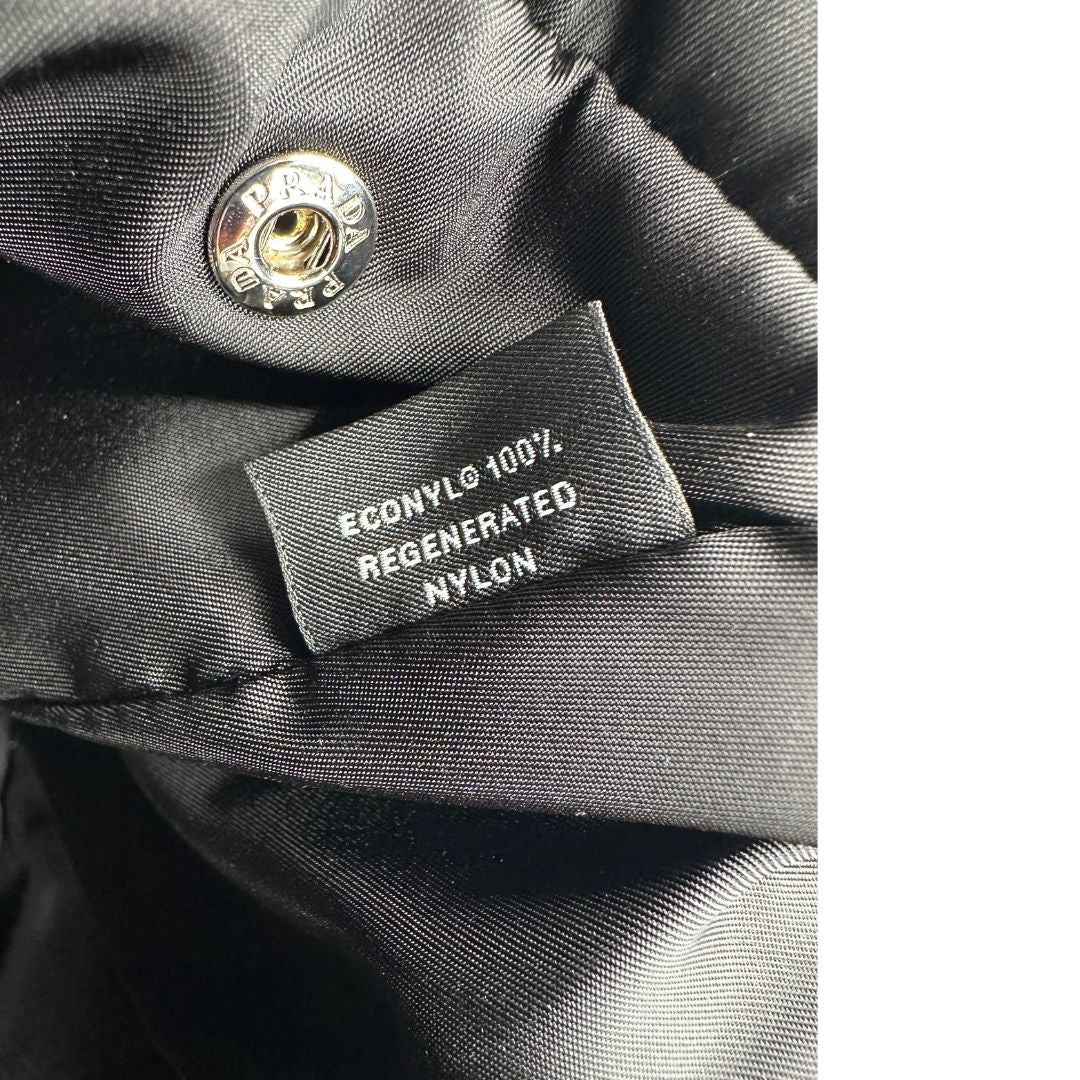 Trasaportino Prada in tessuto nylon imbottito nero con parti metalliche argentate; munito di doppie manici. Da portare a mano. Originale, usato, di lusso, in condizioni eccellenti.