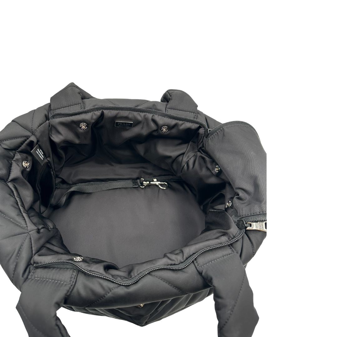 Interno di un Trasaportino Prada in tessuto nylon imbottito nero con parti metalliche argentate; munito di doppie manici. Da portare a mano. Originale, usato, di lusso, in condizioni eccellenti.