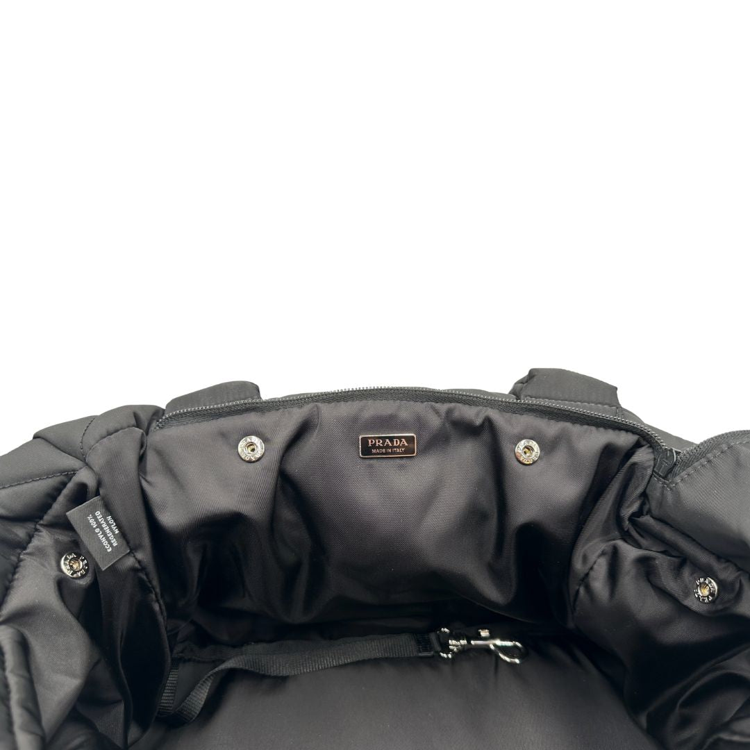Interno di una Trasaportino Prada in tessuto nylon imbottito nero con parti metalliche argentate; munito di doppie manici. Da portare a mano. Originale, usato, di lusso, in condizioni eccellenti.