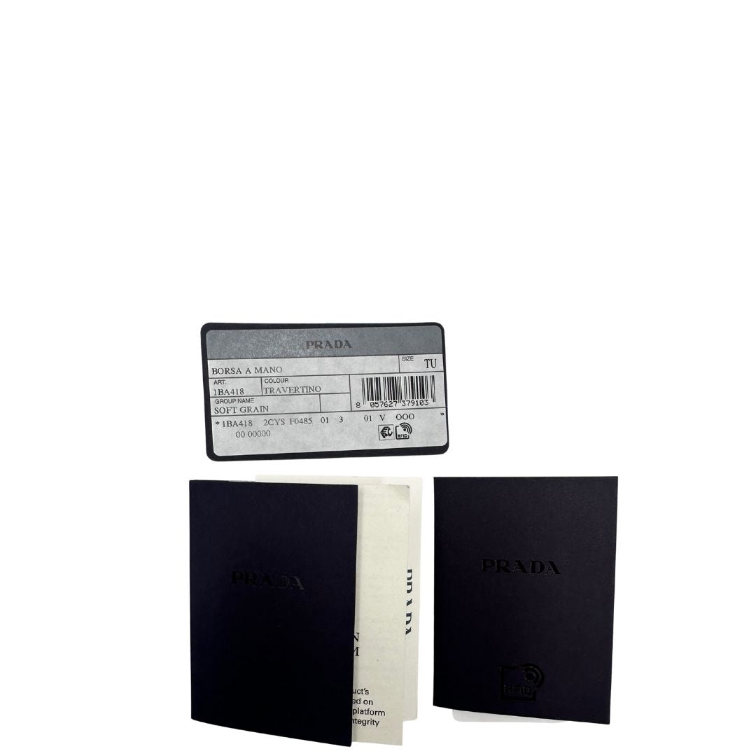 Borsa Prada in pelle color travertino con parti metalliche dorate; impreziosita dal logo lettering impresso a caldo in foglia d'oro 22 carati, munita di doppi manici stondati e una tracolla amovibile e regolabile. Completa di corredo, di lusso, eccellenti condizioni, usata. 