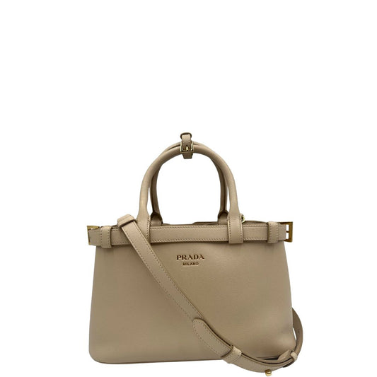 front Borsa Prada in pelle color travertino con parti metalliche dorate; impreziosita dal logo lettering impresso a caldo in foglia d'oro 22 carati, munita di doppi manici stondati e una tracolla amovibile e regolabile. Completa di corredo, di lusso, eccellenti condizioni, usata. 