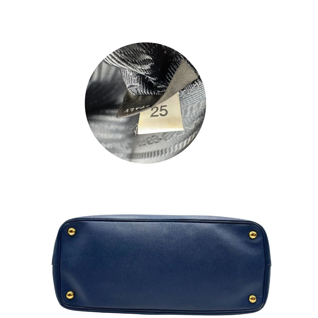 base Borsa Prada in pelle saffiano blu con parti metalliche dorate; munita di doppi manici stondati e impreziosita da una clochette portachiavi, di lusso, originale, ottime condizioni. 