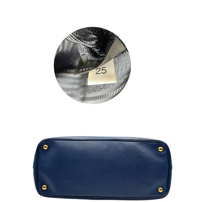 base Borsa Prada in pelle saffiano blu con parti metalliche dorate; munita di doppi manici stondati e impreziosita da una clochette portachiavi, di lusso, originale, ottime condizioni. 