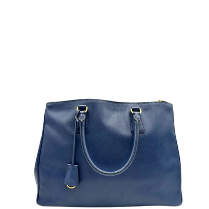 retro Borsa Prada in pelle saffiano blu con parti metalliche dorate; munita di doppi manici stondati e impreziosita da una clochette portachiavi, di lusso, originale, ottime condizioni. v