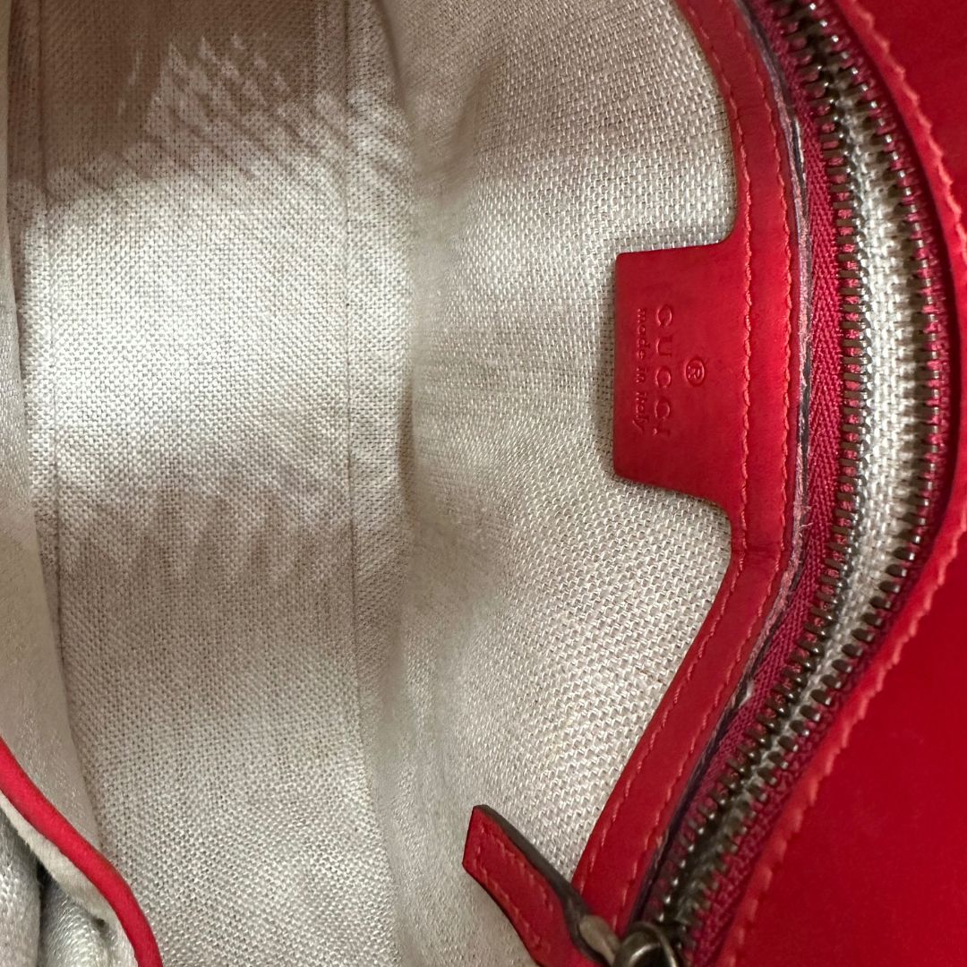 interno della Borsa Gucci in pelle rossa con parti metalliche dorate; munita di doppie tracolle amovibili e regolabili, una tono su tono e una Web rossa e blu. Completa di dustbag, di lusso, originale, ottime condizioni. 