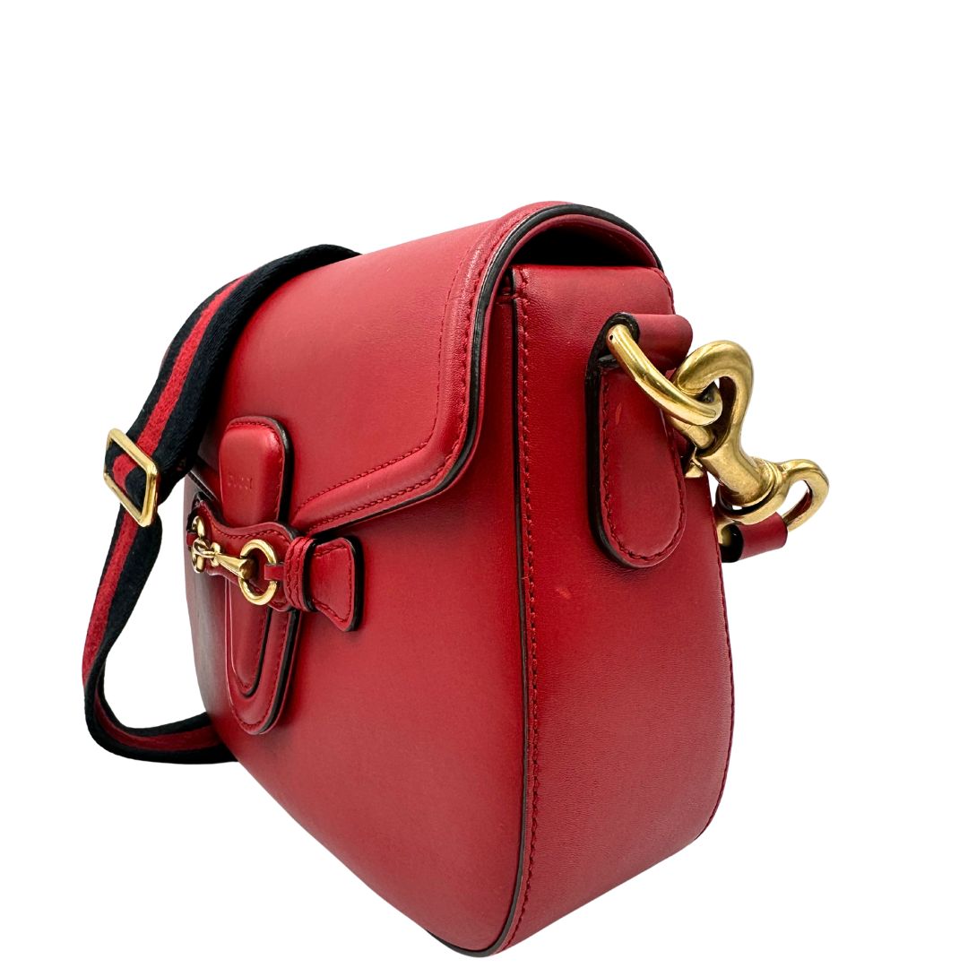 lato Borsa Gucci in pelle rossa con parti metalliche dorate; munita di doppie tracolle amovibili e regolabili, una tono su tono e una Web rossa e blu. Completa di dustbag, di lusso, originale, ottime condizioni. 