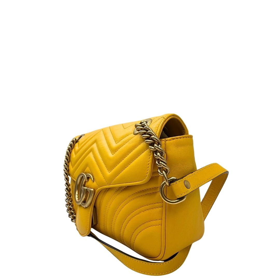 lato Borsa Gucci Marmont in pelle gialla con parti metalliche dorate; impreziosita da doppia G sul front e munita di una tracolla in catena scorrevole con spallaccio in pelle. Completa di dustbag, di lusso, originale, ottime condizioni. 